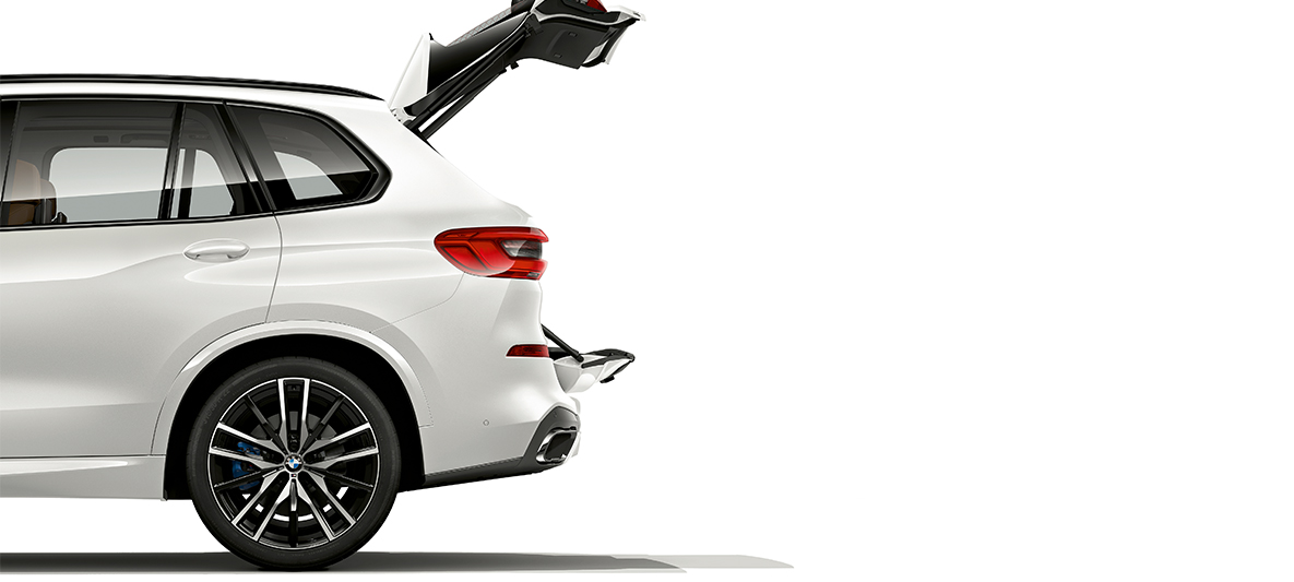 BMW X5 s otvoreným vekom kufra Bočný pohľad na BMW X5, obe časti veka kufra sú otvorené.
