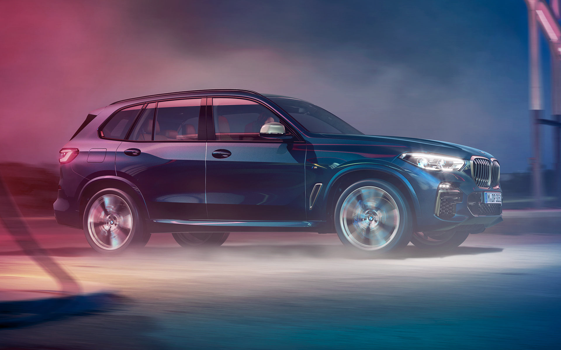 BMW X5 M50d v pohybe Jazdný záber BMW X5 M50d v nočnom mestskom prostredí
