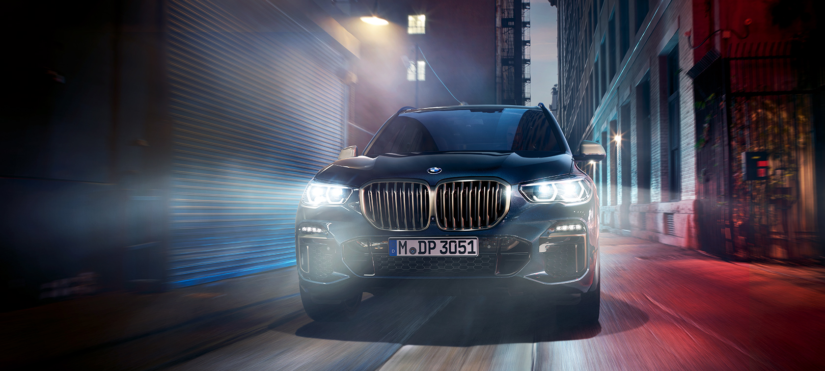 BMW X5 M50d v akcii BMW X5 M50d na nočnej mestskej ulici