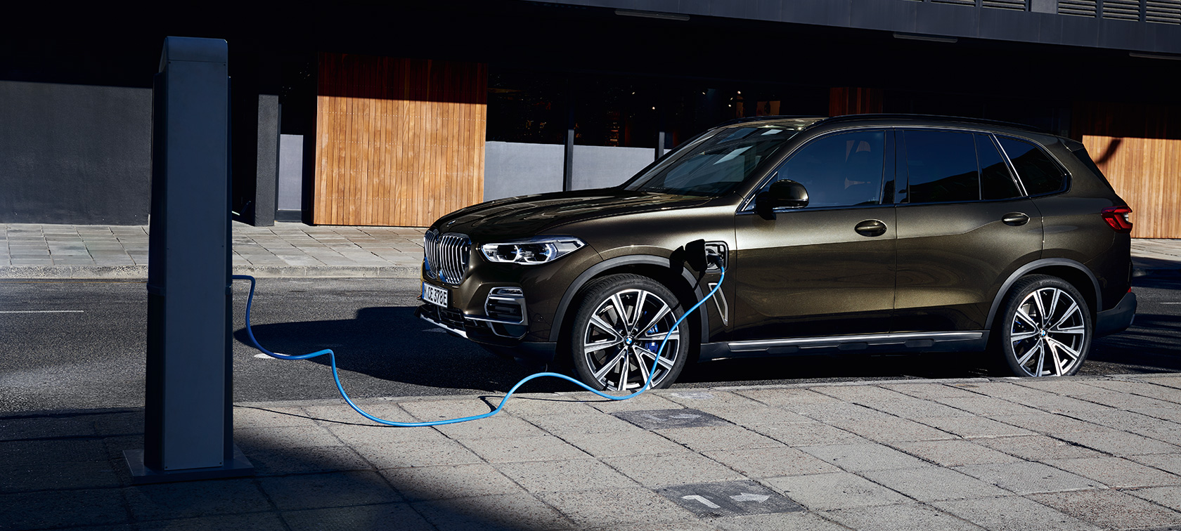 Plug-in hybrid BMW X5 xDrive45e G05 bočný pohľad Plug-in hybrid BMW X5 xDrive45e G05 bočný pohľad počas nabíjania