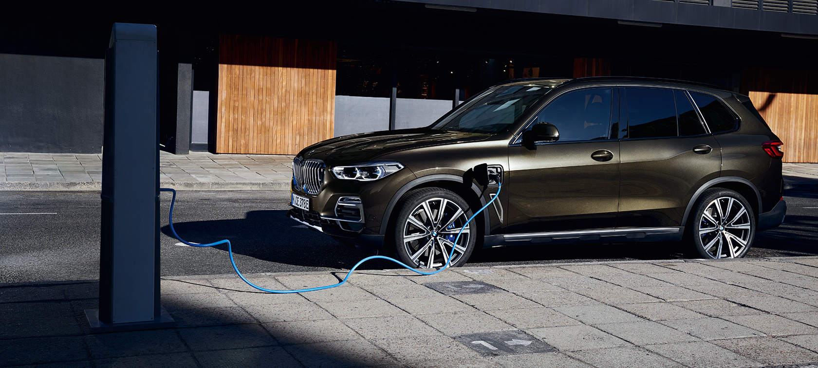 Plug-in hybrid BMW X5 xDrive45e G05 bočný pohľad Plug-in hybrid BMW X5 xDrive45e G05 bočný pohľad počas nabíjania