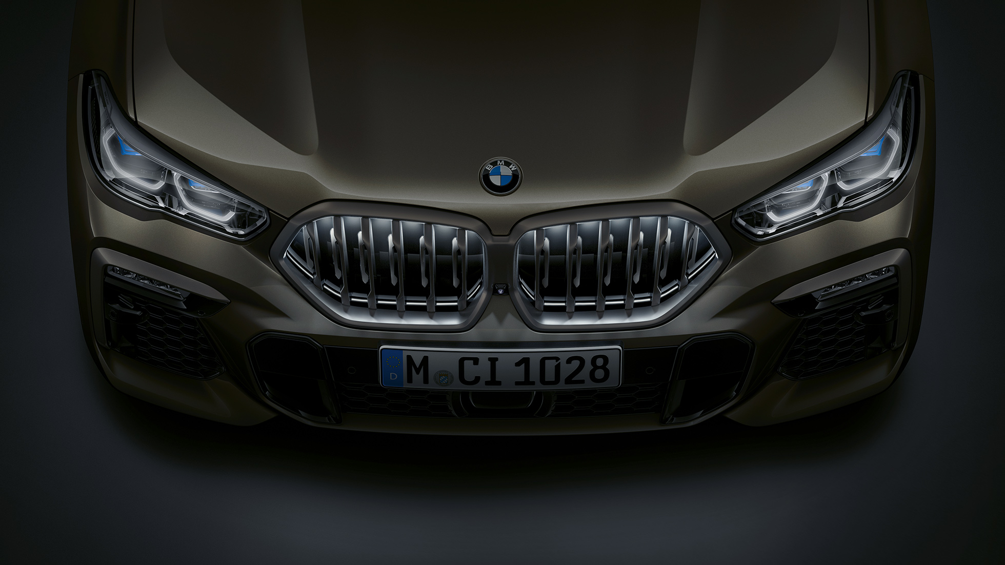 BMW X6 predná časť. Detailný pohľad na prednú časť BMW X6 s BMW mriežkou chladiča Iconic Glow z vtáčej perspektívy.