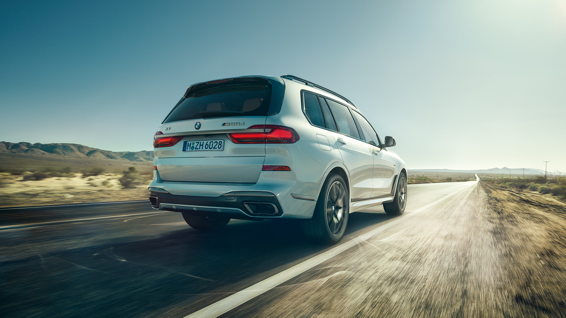 BMW X7 M50d, zadný záber BMW X7 M50d: zadný jazdný záber na biele BMW X7