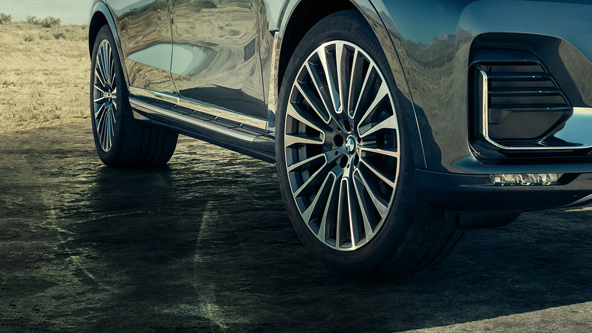 22“ disky z ľahkej zliatiny 22“ disky z ľahkej zliatiny: predobočný pohľad na BMW X7 so zameraním na kolesá