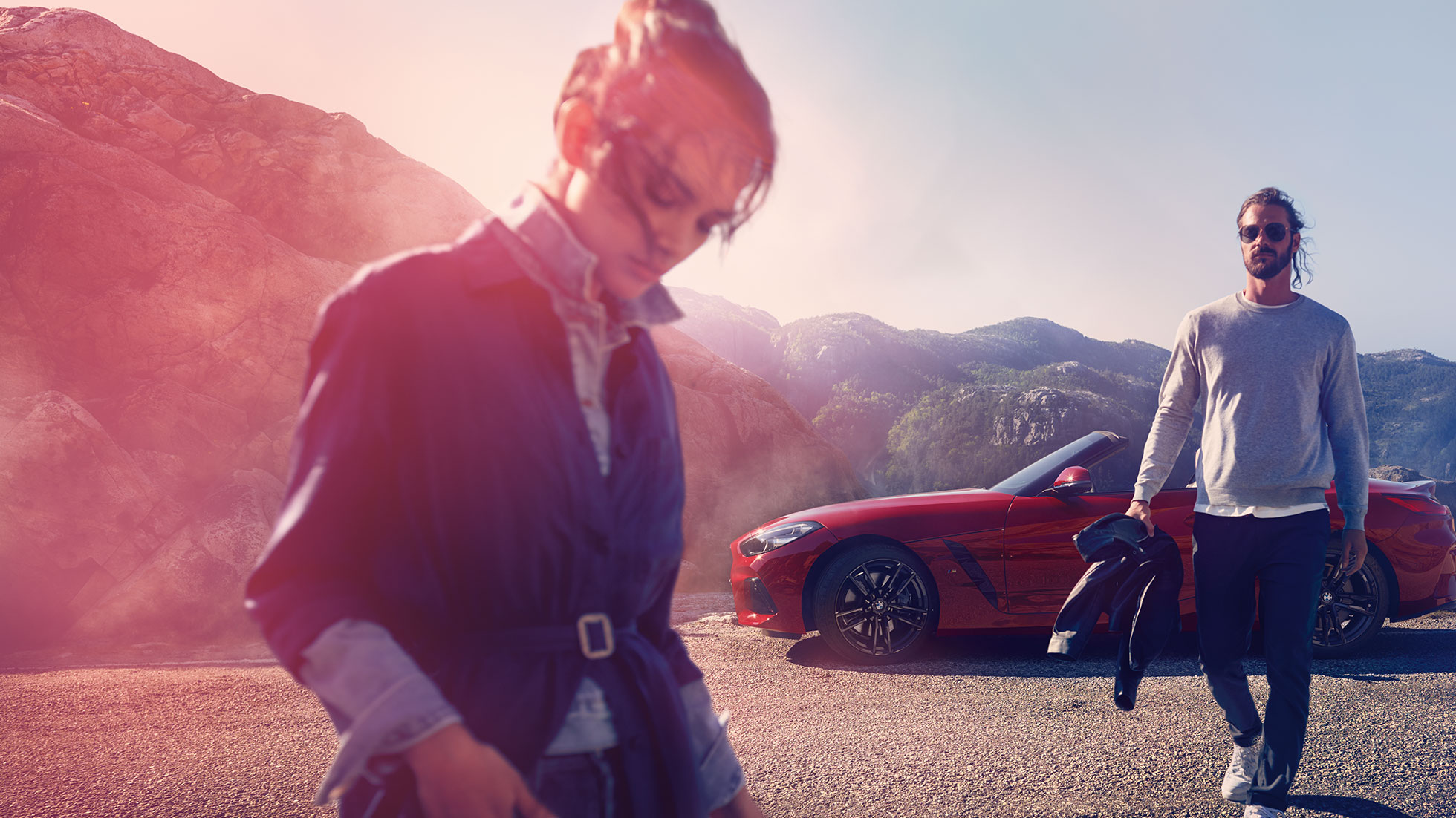 BMW Z4 Roadster s horami v pozadí Muž, žena a BMW Z4 Roadster s horami v pozadí