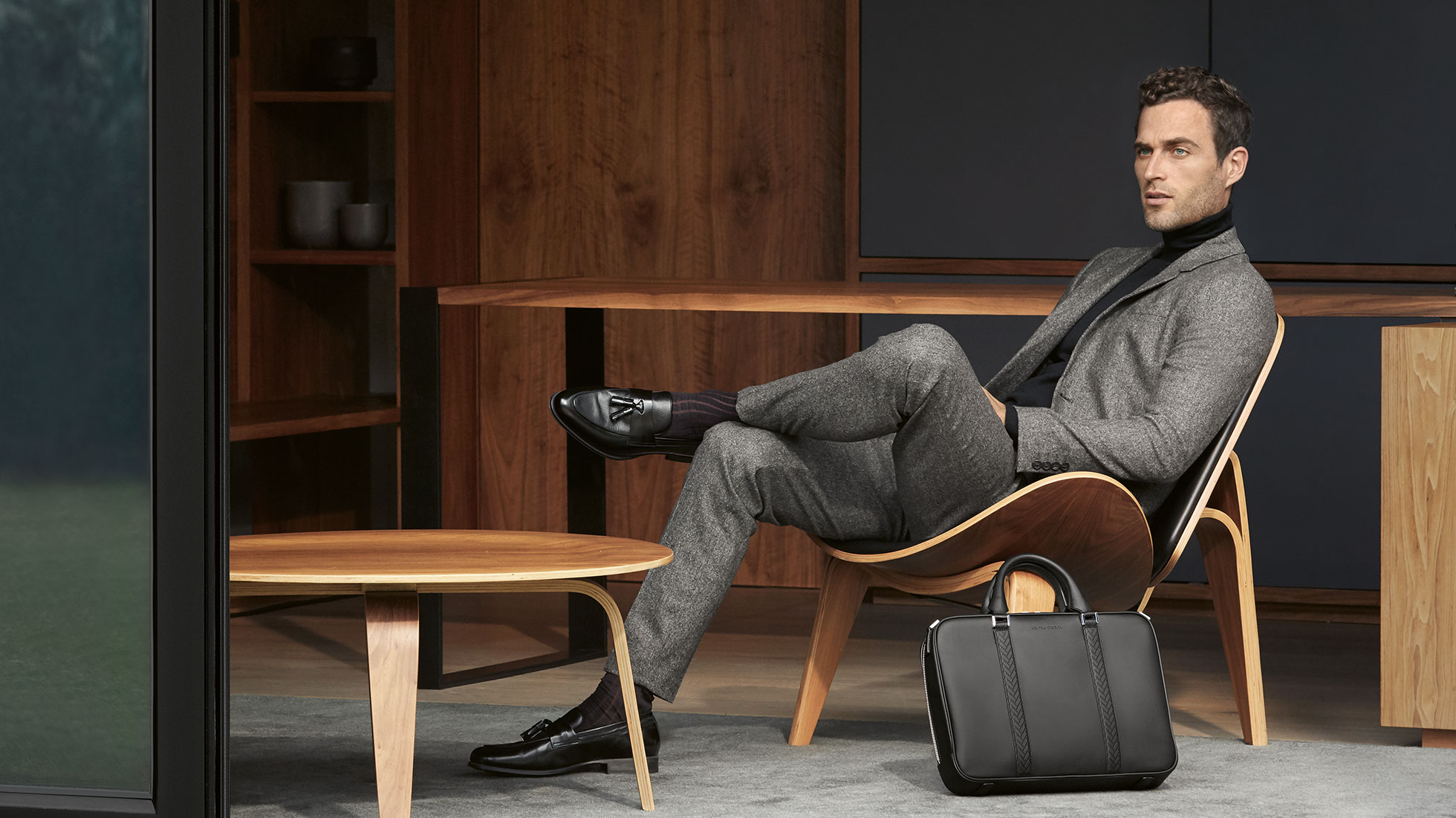 BMW The Collection. Na obrázku je sediaci muž v obleku, ktorý predstavuje produkty z BMW The Collection.
