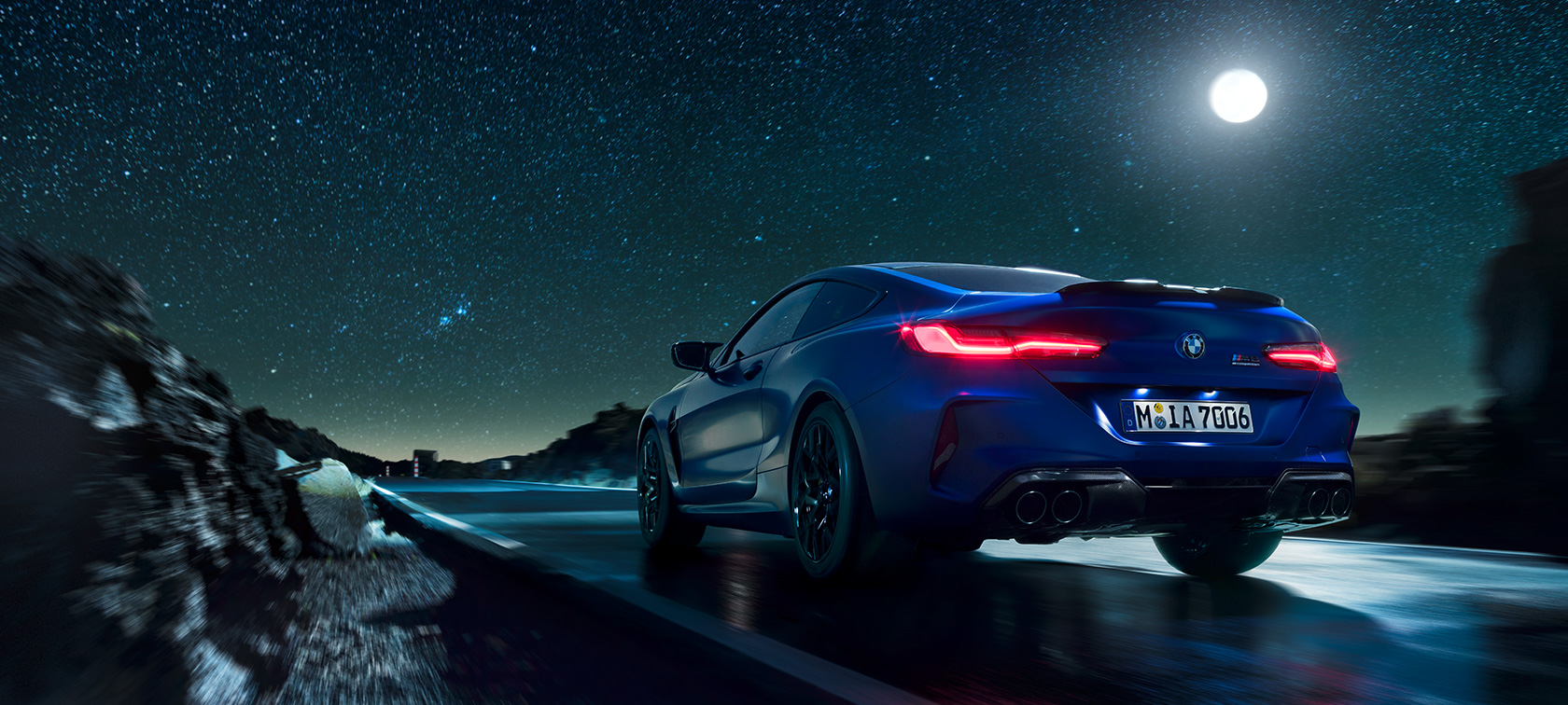 BMW M8 Competition Coupé, zadný pohľad. BMW M8 Competition Coupé, zadný pohľad, jazda počas splnu.