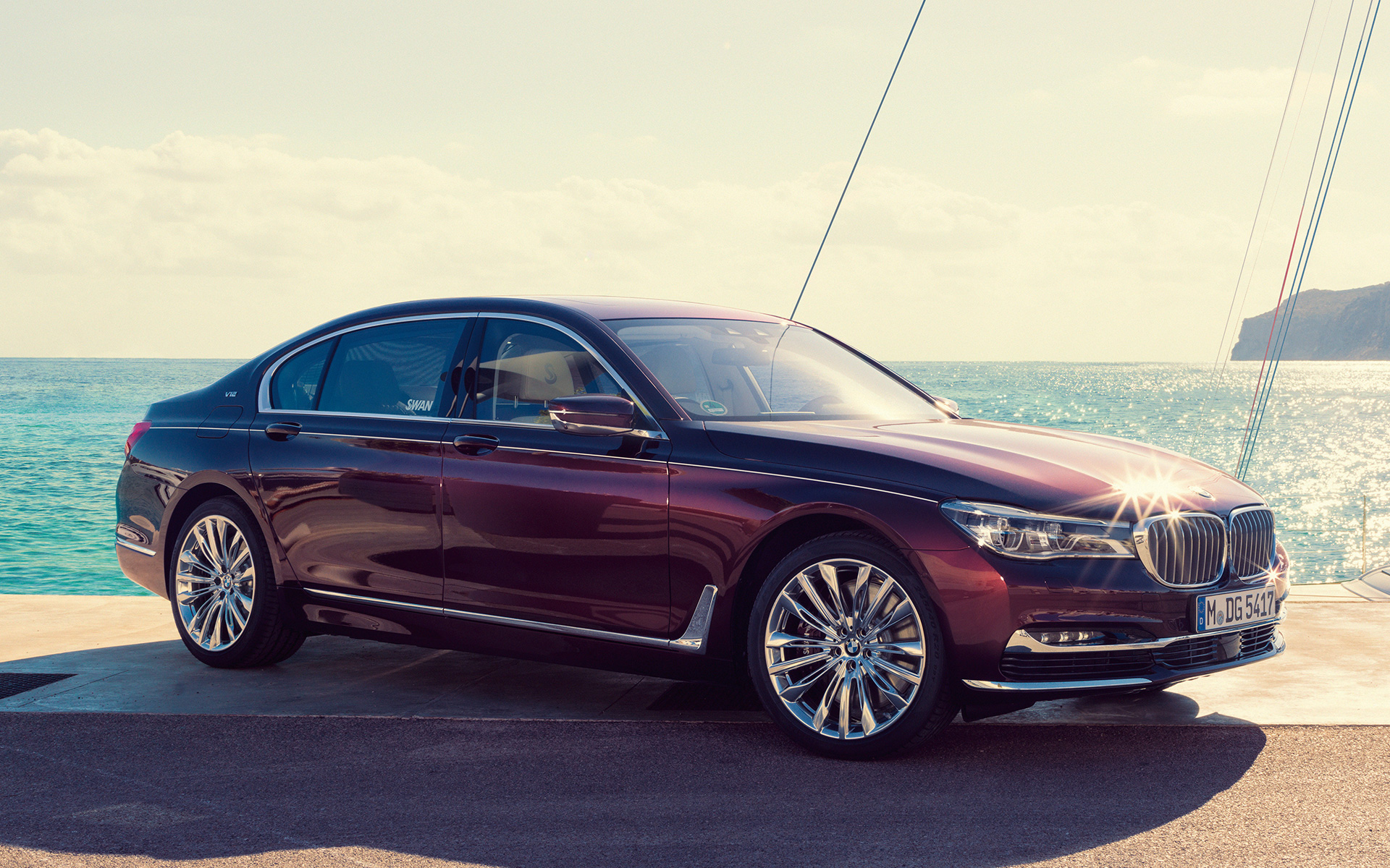 BMW Individual M760Li inspired by Nautor’s Swan G12 2017 pred zakotvenou jachtou BMW Individual M760Li inspired by Nautor’s Swan G12 2017 bočný pohľad statický na móle pred zakotvenou jachtou