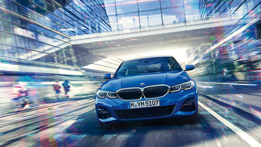 Jazdný záber na modré BMW Jazdný záber na modré BMW so skleneným nadjazdom v pozadí