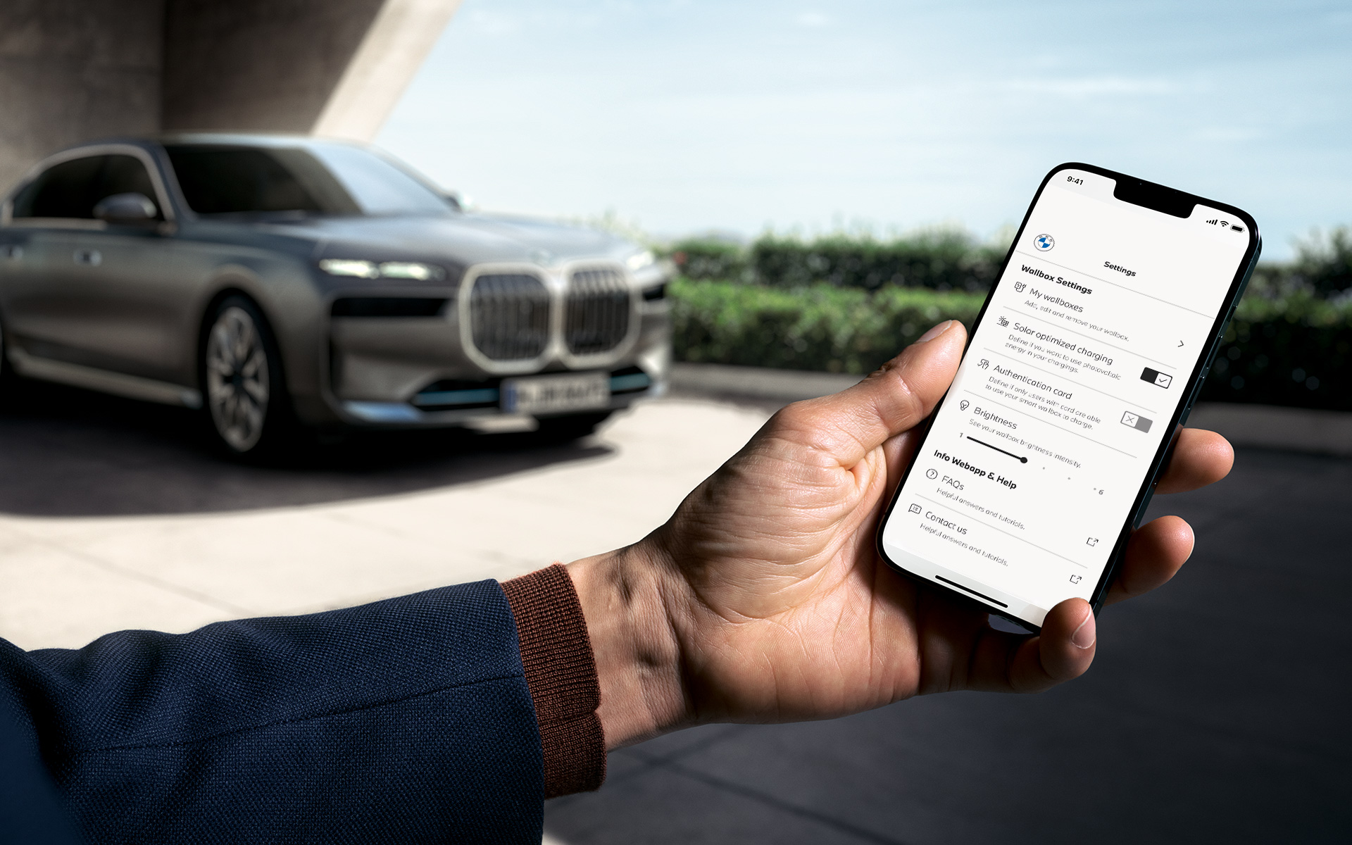 BMW i7 G70 smartfón v popredí zobrazuje aplikáciu My BMW