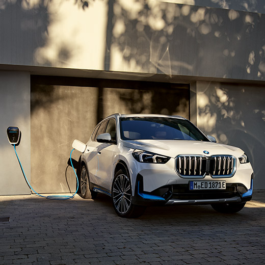 BMW iX1 U11 BEV počas nabíjania pred garážou