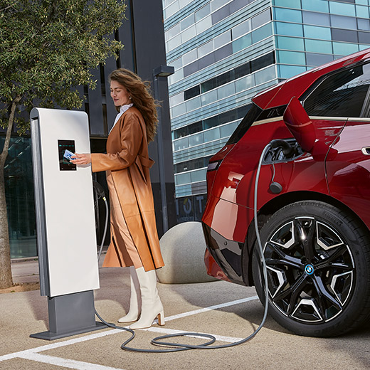 BMW iX i20 na nabíjacej stanici žena s kartou BMW Charging Card