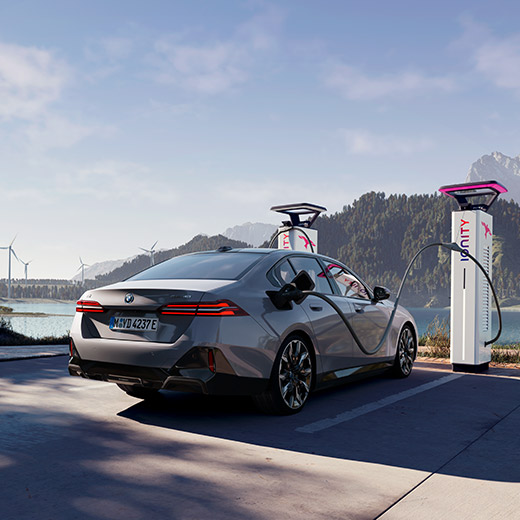 BMW i5 eDrive40 G60 na nabíjacej stanici pred jazerom