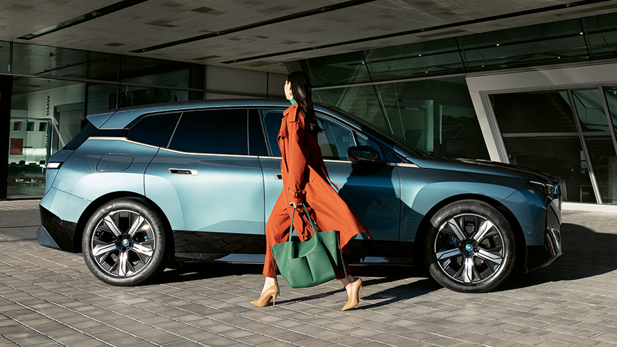 BMW Digital Key benefit BMW Digital Key benefit BMW iX i20 bočný pohľad so ženou v popredí