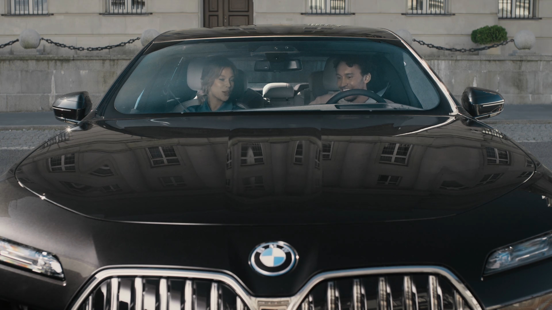 BMW iDrive Challenge Sightseeing BMW iDrive Challenge Sightseeing G70 predný pohľad s dvoma osobami pozerajúcimi sa na BMW Curved Display