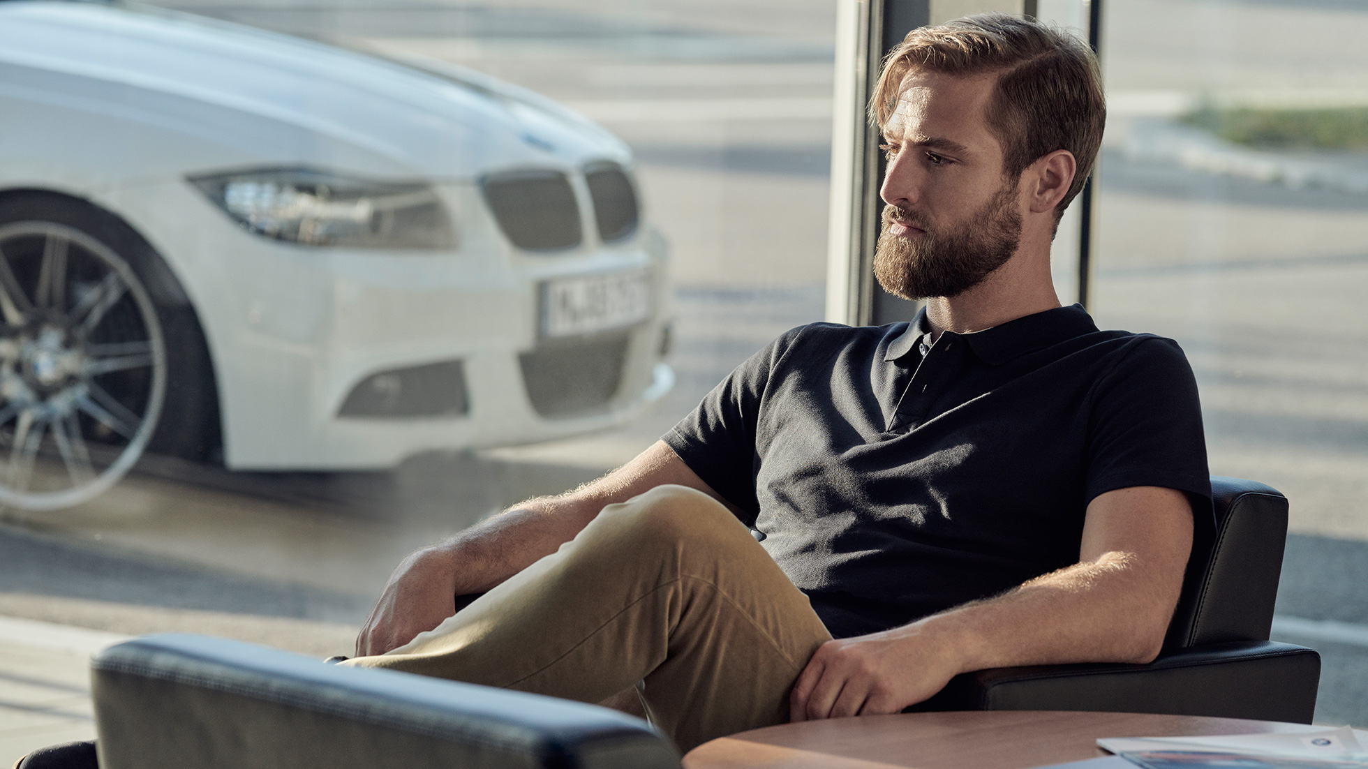 BMW servis Balík BMW Service Inclusive BMW servis Muž s balíkom BMW Service Inclusive sedí uvoľnene u predajcu BMW
