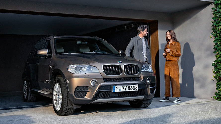 BMW stojace pred garážou s modelmi Balík BMW Value Service, BMW stojace pred garážou s modelmi