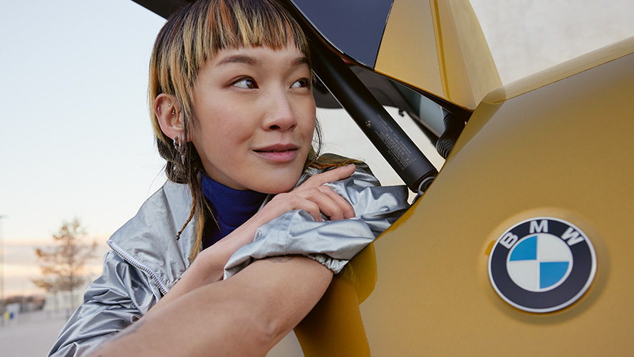Trvanie a zmluvné obdobia balíkov BMW Service Inclusive pre jazdené vozidlá Žena s balíkom BMW Service Inclusive vykúka z batožinového priestoru BMW X2