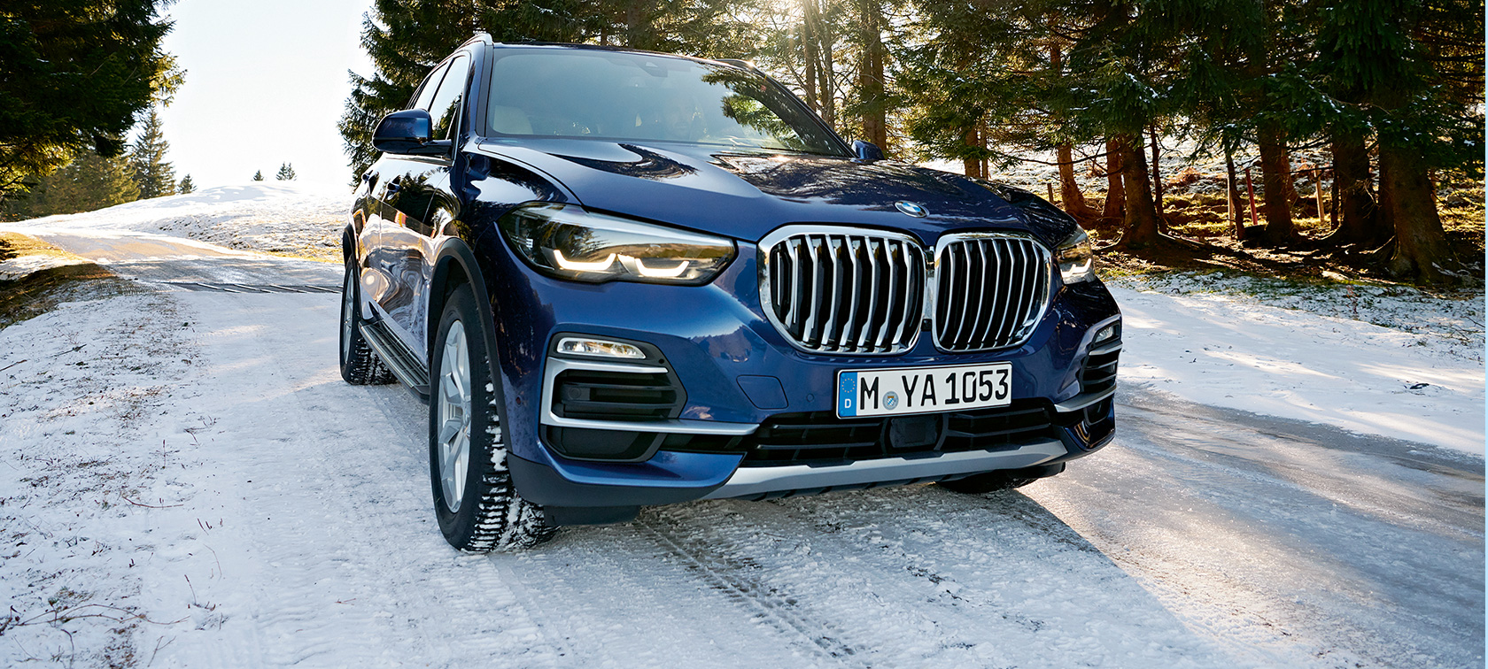 BMW príslušenstvo na jeseň a zimu BMW X3 v modrej farbe na zasneženej ceste, trojštvrťový predný pohľad