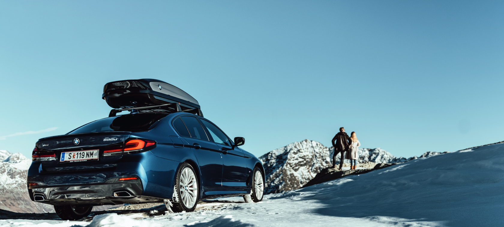 Originálne BMW príslušenstvo a BMW servis na jeseň a zimu Žena a muž smejúci sa na snehovom tobogáne
